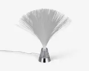 Dekorativ lampe med en vifteformet samling af fine, gennemsigtige fiberoptiske tråde, der spreder sig ud fra en central base. Basen er i metallisk sølv med en klar sektion fyldt med glimmer, og lampen har en synlig ledning til strøm. Fibrene lyser op, når lampen tændes, og skaber en glitrende, lysdiffuserende effekt.