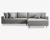 Moderne L-formet sofa med lysegråt stofbetræk, rene linjer og et minimalistisk design. Sofaen har fem løse ryghynder og to matchende pyntepuder for ekstra komfort. Sædehynderne er let knapstukne for et diskret dekorativt udtryk. Sofaen står på korte, skrå træben i naturfarve, som giver stabilitet og et moderne udtryk. Chaiselong-delen er placeret til højre, når man ser på sofaen forfra.