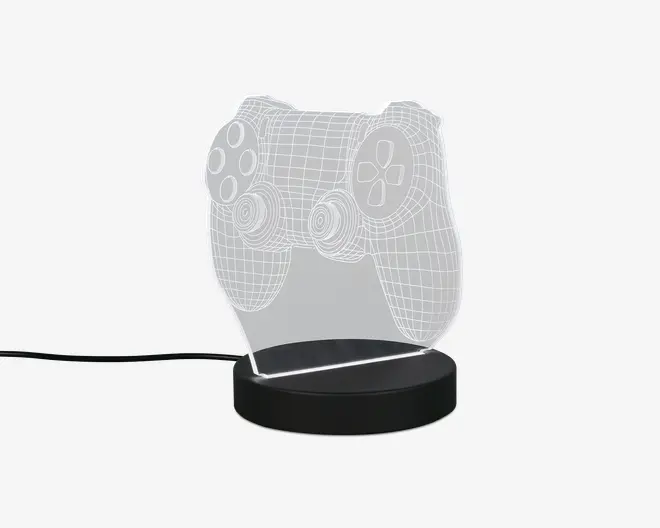 En dekorativ LED-lampe med en klar akrylplade, der er indgraveret med et 3D wireframe-design af en videospil-controller. Pladen er monteret på en rund, sort base, som indeholder LED-lyskilden. Lampen får strøm via et synligt USB-kabel, hvilket gør den velegnet til skriveborde eller natborde. De indgraverede linjer lyser op, når lampen er tændt, og fremhæver detaljerne i controller-designet.