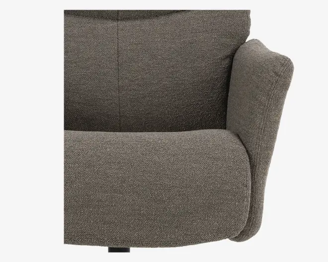 Nærbillede af en stol med blødt, tekstureret stof i en neutral brungrå farve. Sædet og ryglænet er tykt polstret for ekstra komfort, og armlænene er brede og afrundede, hvilket giver god støtte. Syningerne er diskrete og pæne, hvilket bidrager til et moderne og hyggeligt udtryk.