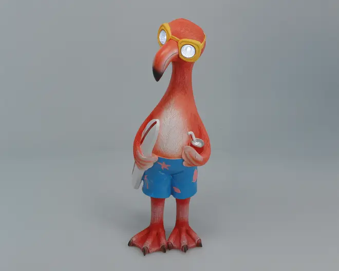 En fantasifuld flamingo-figur med klare orange og pink farver, iført gule svømmebriller og blå badebukser med lyserøde søstjerne-mønstre. Flamingoen holder et hvidt surfbræt under den ene vinge og en sølvfarvet drikkedåse i den anden, og står oprejst med svømmefødderne synlige.