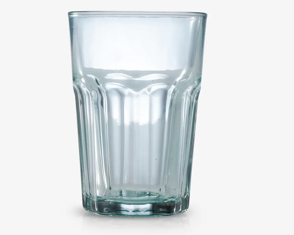 Klar glastumbler med tyk bund og lodrette riller langs siderne for bedre greb. Glasset har en let konisk form, der er bredere øverst og smallere nederst, samt en glat kant for behagelig drikning.