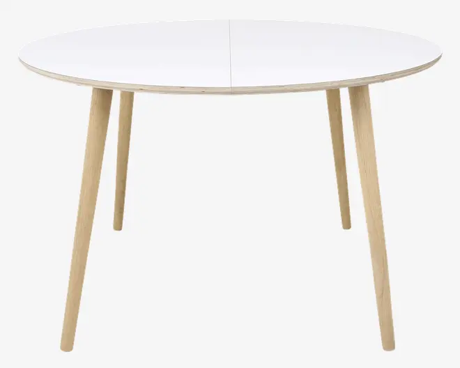 Rundt bord med en glat, hvid bordplade og fire skråtstillede ben i lyst træ. Bordpladen har en diskret samling i midten, hvilket antyder, at det muligvis kan udvides. Designet er minimalistisk og moderne med rene linjer og naturtræ på benene.
