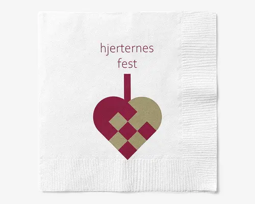 Hvid serviet med trykt design, hvor teksten 'hjerternes fest' står øverst i bordeauxrød skrift. Under teksten er der et stiliseret flettet hjerte, halvt i bordeaux og halvt i guld, med et lodret håndtag, der går op fra hjertets top. Servietten har en tekstureret kant langs bunden og højre side.