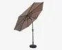 Stor udendørs parasol med ottekantet, taupefarvet dug. Parasollen har en solid, sort metalstang, der er placeret til siden, hvilket giver mere anvendelig skygge under dugen. Stangen er fastgjort til en tung, rund fod for stabilitet. Dugen holdes udspændt af flere metalstænger, og parasollens vinkel kan justeres med et håndsving på stangen.