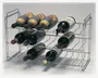 Et metalstativ med kromfinish, designet til at holde op til tolv flasker vandret. Stativet har tre niveauer, hver med fire pladser til flasker, og har åbne sider samt en minimalistisk, rektangulær ramme. Konstruktionen er robust med parallelle stænger, der støtter flaskerne, og håndtag i hver ende for nem transport eller flytning.