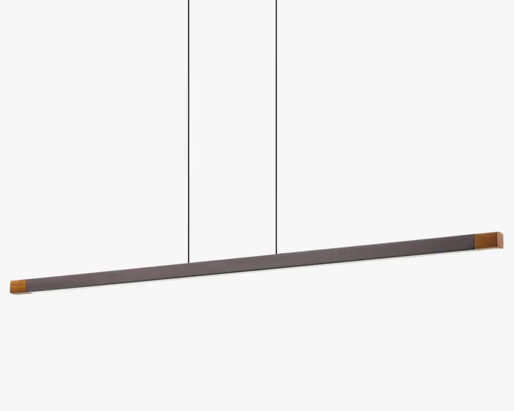 Et moderne, minimalistisk pendellampe med en lang, slank vandret stang, der hænger fra to tynde, lodrette stænger. Stangen har en mat sort finish med diskrete gulddetaljer i begge ender, hvilket giver et stilrent og nutidigt udtryk. Designet er enkelt og diskret, perfekt til at give jævn belysning over et spisebord eller arbejdsområde.