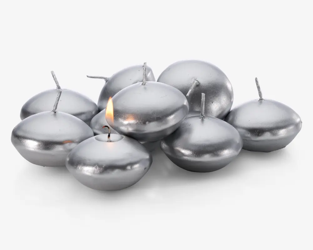 En gruppe runde, sølvfarvede flydelys med en glat, metallisk overflade. Hvert lys har en kort væge i midten, og ét af lysene er tændt med en lille flamme. Lysene har en let fladtrykt, skiveformet facon, der egner sig til at flyde på vand.