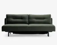 En moderne, minimalistisk sofa med mørkegrønt stofbetræk. Sofaen har to store sædehynder og to ryghynder, hver med diskrete knapdetaljer, der giver ekstra struktur. Armlænene er lave og lige, og sofaen står på fire korte, cylindriske sorte ben. Det samlede design er enkelt og nutidigt, velegnet til forskellige stilarter i stuen.