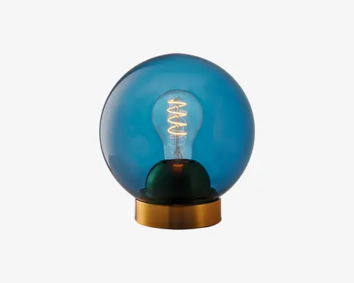 En dekorativ lampe med en rund, blåtonet glaskuppel, der omslutter en synlig spiralformet glødepære. Lampen står på en metallisk guldfarvet base, hvilket giver et moderne og stilfuldt udtryk. Det blå glas blødgør lyset og skaber en varm og hyggelig stemning.