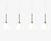 Sæt med fire pendellamper med slanke kromstænger og runde, matterede glasskærme. Designet er moderne og minimalistisk, og hver lampe hænger ned fra en lige stang. Det matterede glas giver et blødt og varmt lys.