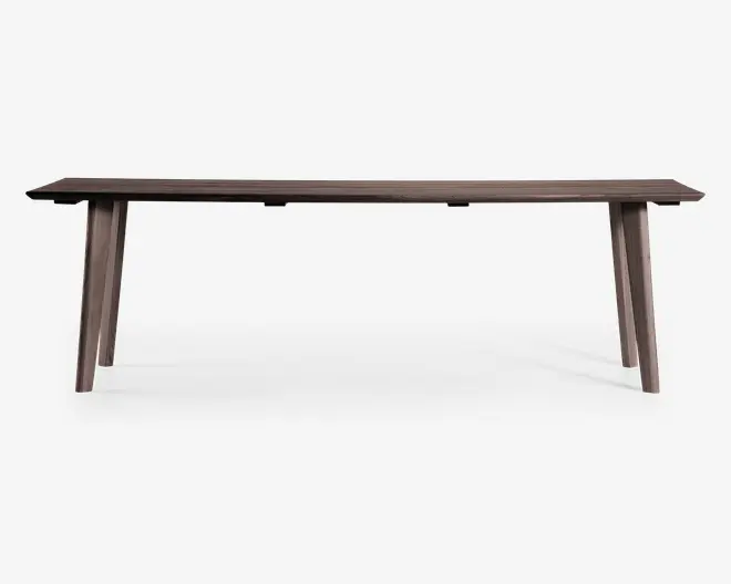 Rektangulært bord i træ med en glat, mørkebrun overflade. Bordpladen er flad med rene, lige kanter. Bordet står på fire skråtstillede ben, som er let tilspidsede, hvilket giver et moderne og minimalistisk udtryk. Designet er enkelt og funktionelt, velegnet til spise- eller arbejdsbrug.