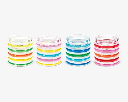 Sæt med fire klare glas, hver dekoreret med vandrette, farverige striber i forskellige kombinationer af grøn, gul, orange, pink og blå. Striberne er jævnt fordelt og går hele vejen rundt om glasset, hvilket giver et legende og livligt udtryk. Hvert glas har sit eget unikke farvemønster, så de er nemme at kende fra hinanden.