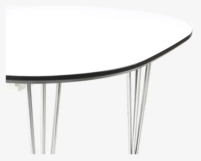 Nærbillede af et bordhjørne med en glat, hvid bordplade og en tynd sort kant. Bordet understøttes af slanke, skråtstillede metalben med blank kromfinish, hvilket giver et moderne og minimalistisk udtryk.