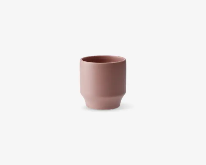 En lille, cylindrisk kop med mat rosa finish. Koppen har en glat overflade, let tilspidset bund og lige kant. Det minimalistiske design giver et moderne og elegant udtryk.