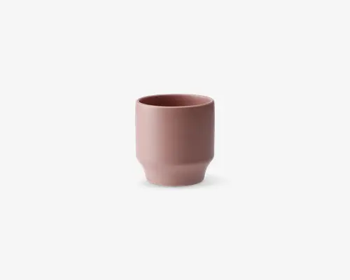 En lille, cylindrisk kop med mat rosa finish. Koppen har en glat overflade, let tilspidset bund og lige kant. Det minimalistiske design giver et moderne og elegant udtryk.