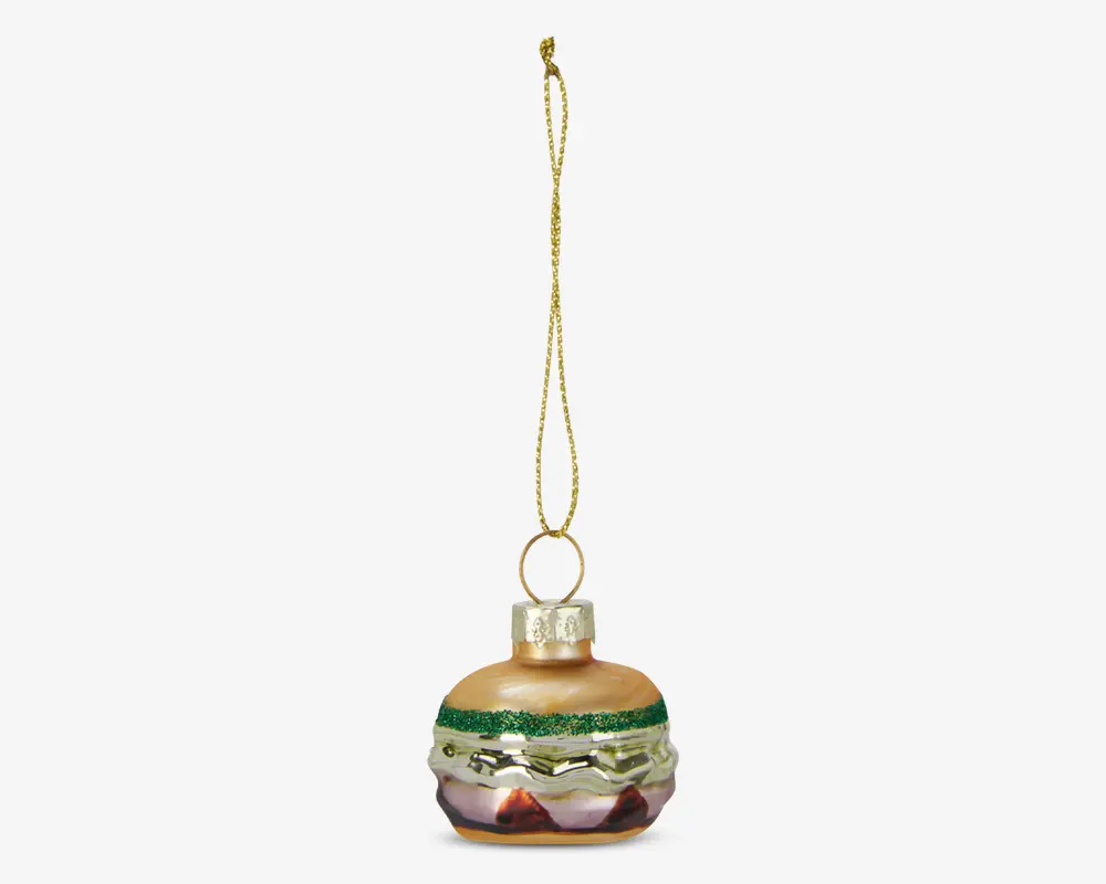 Et glasornament formet og malet som en burger med lag i brune nuancer til bollen, grøn glimmer til salat, gul til ost og rød til tomat. Ornamentet har en blank overflade og leveres med en gylden ophængssnor fastgjort til en metalhætte.