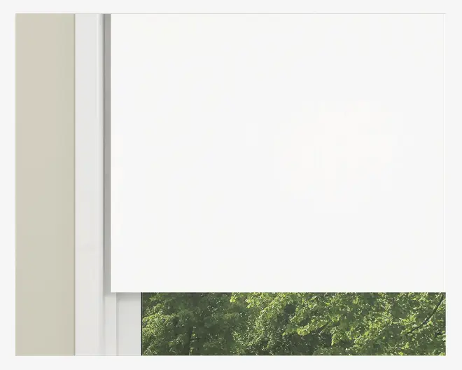 Et nærbillede af et vindue med en enkel, hvid rullegardin, der er delvist rullet ned. Gardinet har en glat, ensartet overflade uden synlige mønstre eller teksturer, hvilket giver et rent og minimalistisk udtryk. Vinduesrammen er hvid, og en del af grønne træer kan ses udenfor gennem den nederste, åbne del af vinduet.