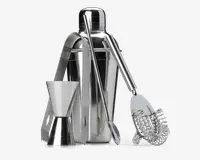 Et sæt barværktøj i rustfrit stål, der inkluderer en cocktailshaker med tætsluttende låg, en dobbeltsidet målebæger til væsker, en lang røreske, en fjeder cocktail-si og et par istænger. Alle dele har en blank, poleret overflade og er designet til holdbarhed og nem rengøring.