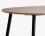 Rund bordplade med lys træfinish og glatte kanter, understøttet af skrå sorte metalben. Designet er minimalistisk og moderne med en slank profil og rene linjer.