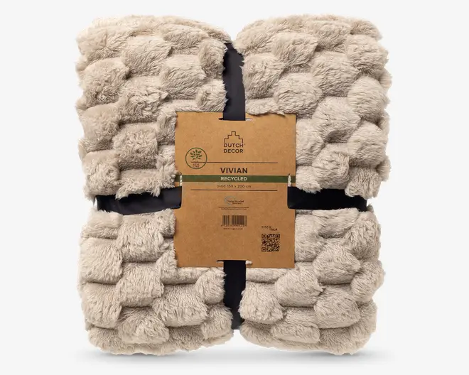 Blød beige plaid med imiteret pels og et kraftigt, fluffy teksturmønster, foldet i en firkant og samlet med et brunt papband.