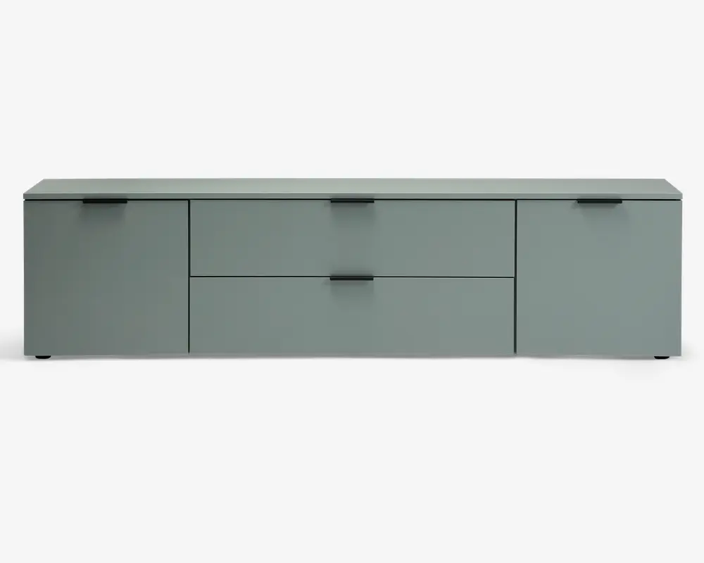 Et moderne, lavt opbevaringsmøbel i en afdæmpet grøn farve med mat finish. Møblet har to store låger i hver side og to rummelige, centralt placerede skuffer oven på hinanden. Hver låge og skuffe har et minimalistisk sort greb, og det samlede design er strømlinet og uden synlige håndtag bortset fra de små greb. Overfladen er flad og glat, velegnet til dekoration eller elektronik.