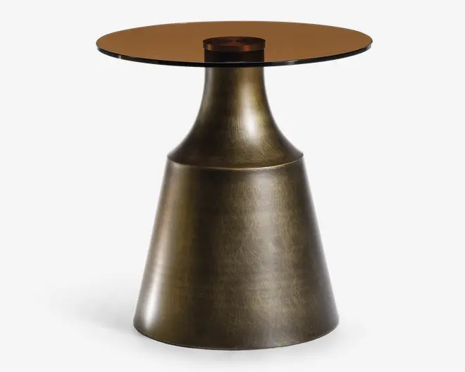 Et moderne sidebord med en konisk base i børstet messingfinish og en let tekstureret overflade. Bordpladen er rund og lavet af tonet glas, understøttet af en lille, central trædetalje. Designet kombinerer metal og glas for et elegant og nutidigt udtryk.