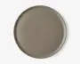 En rund tallerken med en glat, mat overflade i taupe farve. Tallerkenen har en let forhøjet kant og et minimalistisk, moderne design uden mønstre eller dekorationer.