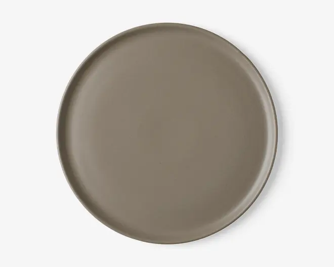 En rund tallerken med en glat, mat overflade i taupe farve. Tallerkenen har en let forhøjet kant og et minimalistisk, moderne design uden mønstre eller dekorationer.