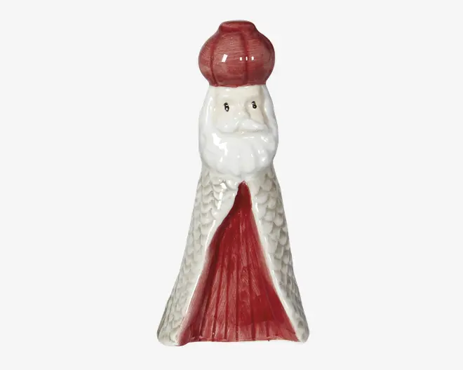 Blank keramisk figurine med hvidt skæg og rød hat, formet som en kegle med hvid krop, rød forside og små malede ansigtstræk.
