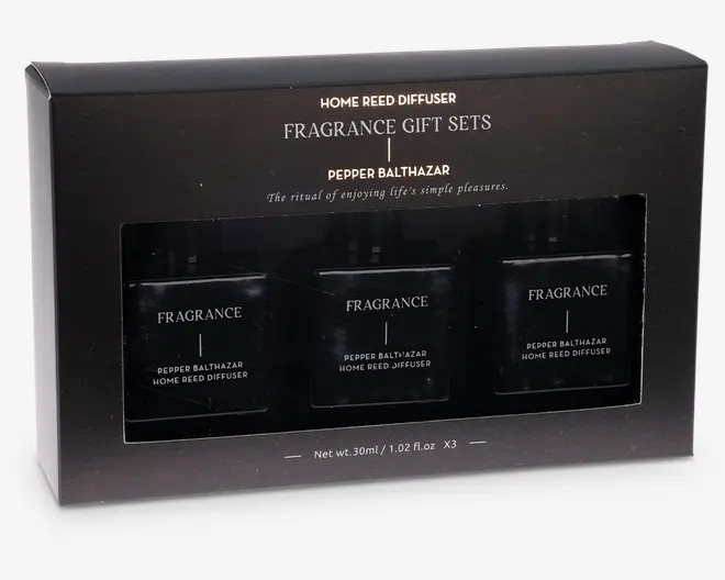 En elegant sort gaveæske indeholdende tre små, firkantede glasflasker med sorte låg, hver mærket 'FRAGRANCE PEPPER BALTHAZAR HOME REED DIFFUSER.' Emballagen har stilfuld hvid og gylden tekst, der fremhæver det som et duft-gavesæt med duften 'Pepper Balthazar.' Sættet indeholder tre flasker, hver med et nettovægt på 30 ml (1,02 fl.oz). Det samlede design er moderne og luksuriøst, velegnet som gave.