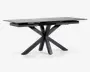 Rektangulært bord med en elegant, mat sort finish. Bordpladen er flad og glat, understøttet af en markant geometrisk base med fire skråtstillede ben, der mødes i midten og giver et moderne, skulpturelt udtryk. Bordet fremstår robust og rummeligt, velegnet til spise- eller arbejdsbrug.