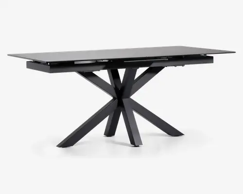 Rektangulært bord med en elegant, mat sort finish. Bordpladen er flad og glat, understøttet af en markant geometrisk base med fire skråtstillede ben, der mødes i midten og giver et moderne, skulpturelt udtryk. Bordet fremstår robust og rummeligt, velegnet til spise- eller arbejdsbrug.