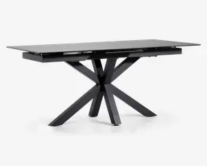 Rektangulært bord med en elegant, mat sort finish. Bordpladen er flad og glat, understøttet af en markant geometrisk base med fire skråtstillede ben, der mødes i midten og giver et moderne, skulpturelt udtryk. Bordet fremstår robust og rummeligt, velegnet til spise- eller arbejdsbrug.