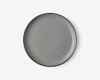 Rund tallerken med en glat, blank lysegrå overflade og en tynd, let hævet kant. Tallerkenens kant er diskret mørkere, hvilket giver et minimalistisk og moderne udtryk. Tallerkenen ser ud til at være lavet af keramik eller porcelæn.