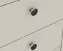 Nærbillede af to skuffer med glatte, matte lyse beige overflader. Hver skuffe har en rund, metalgreb med børstet finish og en let hævet base, hvilket giver et moderne og minimalistisk udtryk. Skuffefronterne er flade med rene linjer og uden synlige samlinger eller dekorative detaljer.