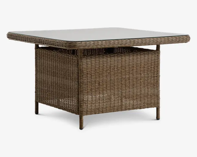 Firkantet bord med glasplade og base i fletlook. Bordet har afrundede hjørner og en solid, kasseformet understøtning under bordpladen, hvilket giver et moderne og naturligt udtryk. Den flettede tekstur dækker hele basen, og benene er slanke og integreret i designet for et ensartet udseende.