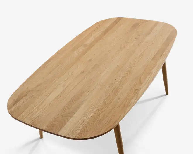 Et rektangulært bord i træ med afrundede hjørner og en glat, naturlig finish. Bordpladen har et synligt træmønster, og bordet står på fire let tilspidsede ben. Designet er minimalistisk og moderne og fremhæver træets naturlige skønhed.