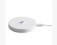 En rund, flad, hvid base med en glat overflade og et lille gevindhul i midten, beregnet til montering af en anden komponent. Basen har et USB-C kabel tilsluttet på siden til strøm eller dataoverførsel.
