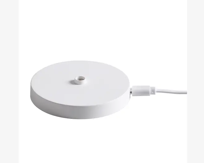 En rund, flad, hvid base med en glat overflade og et lille gevindhul i midten, beregnet til montering af en anden komponent. Basen har et USB-C kabel tilsluttet på siden til strøm eller dataoverførsel.