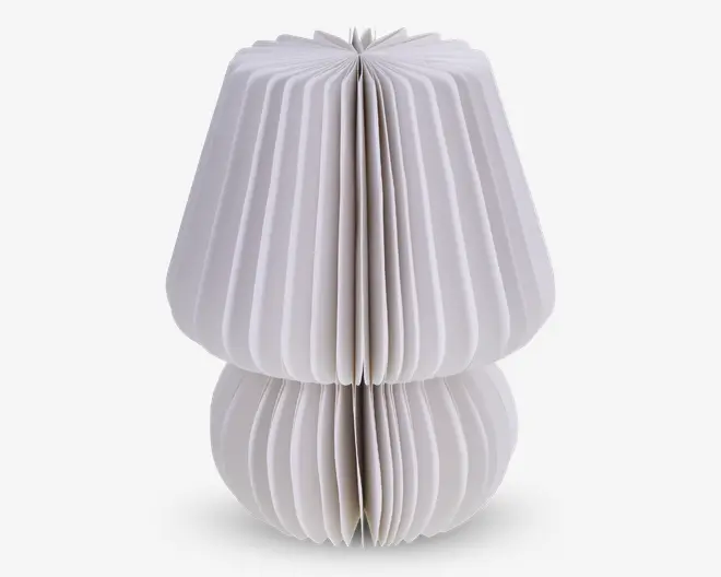 Et dekorativt objekt med et skulpturelt, geometrisk design lavet af foldet hvidt papir. Objektet har en rundet bund og en bredere, udadgående top, der minder om en svamp eller en lampeskærm. Papiret er plisseret i jævnt fordelte lodrette folder, hvilket giver et tekstureret og symmetrisk udseende.
