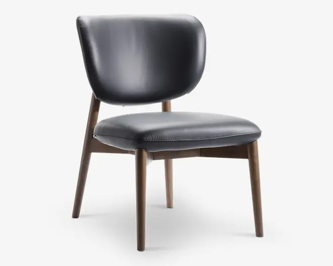 Stol med buet, polstret ryglæn og tyk, polstret sæde betrukket med glat, mørkt læder. Benene er lavet af lyst træ med en let tilspidset form, hvilket giver et moderne og elegant udtryk. Syningerne på sædet tilføjer en diskret dekorativ detalje.