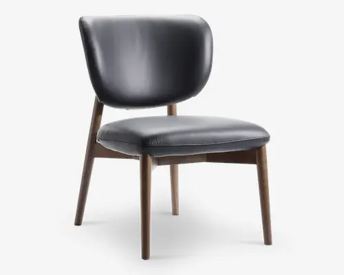 Stol med buet, polstret ryglæn og tyk, polstret sæde betrukket med glat, mørkt læder. Benene er lavet af lyst træ med en let tilspidset form, hvilket giver et moderne og elegant udtryk. Syningerne på sædet tilføjer en diskret dekorativ detalje.
