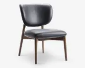 Stol med buet, polstret ryglæn og tyk, polstret sæde betrukket med glat, mørkt læder. Benene er lavet af lyst træ med en let tilspidset form, hvilket giver et moderne og elegant udtryk. Syningerne på sædet tilføjer en diskret dekorativ detalje.