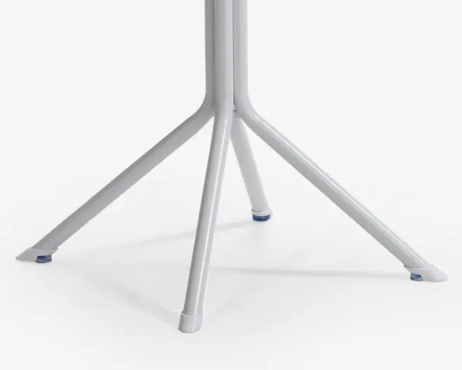 Nærbillede af en firbenet metalbase med hvid finish. Hver ben er let vinklet udad for stabilitet og har en lille blå skridsikker fod for enden. Benene samles i midten og danner en solid støtte.