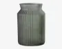 Høj cylindrisk beholder lavet af mat glas med et svagt grønligt skær. Overfladen har lodrette rillede linjer, der giver tekstur, og halsen er let udvidet med en glat kant. Designet er minimalistisk og moderne.
