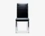Moderne stol med sort kunstlæderpolstret sæde og ryglæn, der har vandrette syninger øverst på ryggen. Stolen har et stilrent, rektangulært design med krombelagte metalben, som er let vinklet for stabilitet.