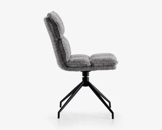 Sidevisning af en moderne stol med tykt polstret sæde og ryglæn i tekstureret gråt stof. Stolen har en sort metalfod med fire skråtstillede ben, der giver stabilitet og et moderne udtryk. Sæde- og ryghynderne ser bløde og komfortable ud med et let buet, ergonomisk design.