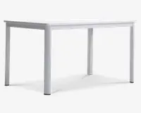 Rektangulært bord med en glat, flad hvid overflade og fire lige ben. Designet er minimalistisk og moderne med rene linjer og uden synlige dekorative elementer. Benene er placeret i hvert hjørne, hvilket giver stabilitet og god benplads under bordet. Bordet ser ud til at være lavet af et robust materiale, velegnet til forskellige formål som spisning, arbejde eller studier.