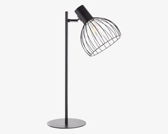 En moderne bordlampe med mat sort metalfinish. Lampen har en cylindrisk stang og en rund, flad fod for stabilitet. Lampeskærmen er udformet som en åben, bur-lignende trådkonstruktion, hvilket gør pæren fuldt synlig. Pæren sidder i en sort fatning, der er vinklet nedad, hvilket giver lampen et industrielt og moderne udtryk.